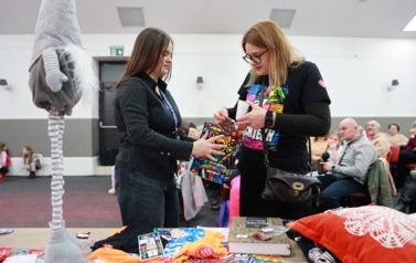 Kobieta wrzuca pieniądze do puszki 