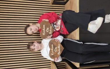 Dwie dziewczynki siedzą z laurkami 