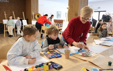 Dzieci pod okiem nauczycielki malują 